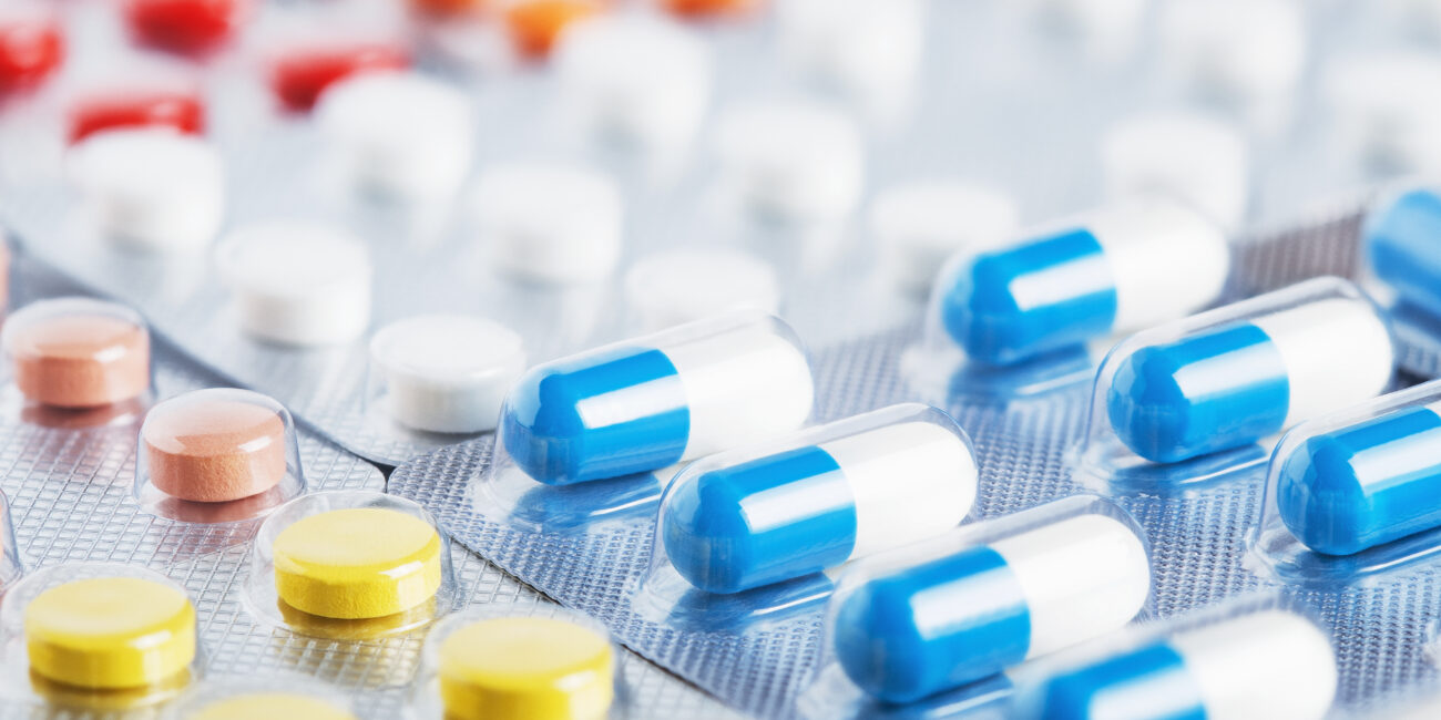 Heap of medical pills in white, blue and other colors. Pills in