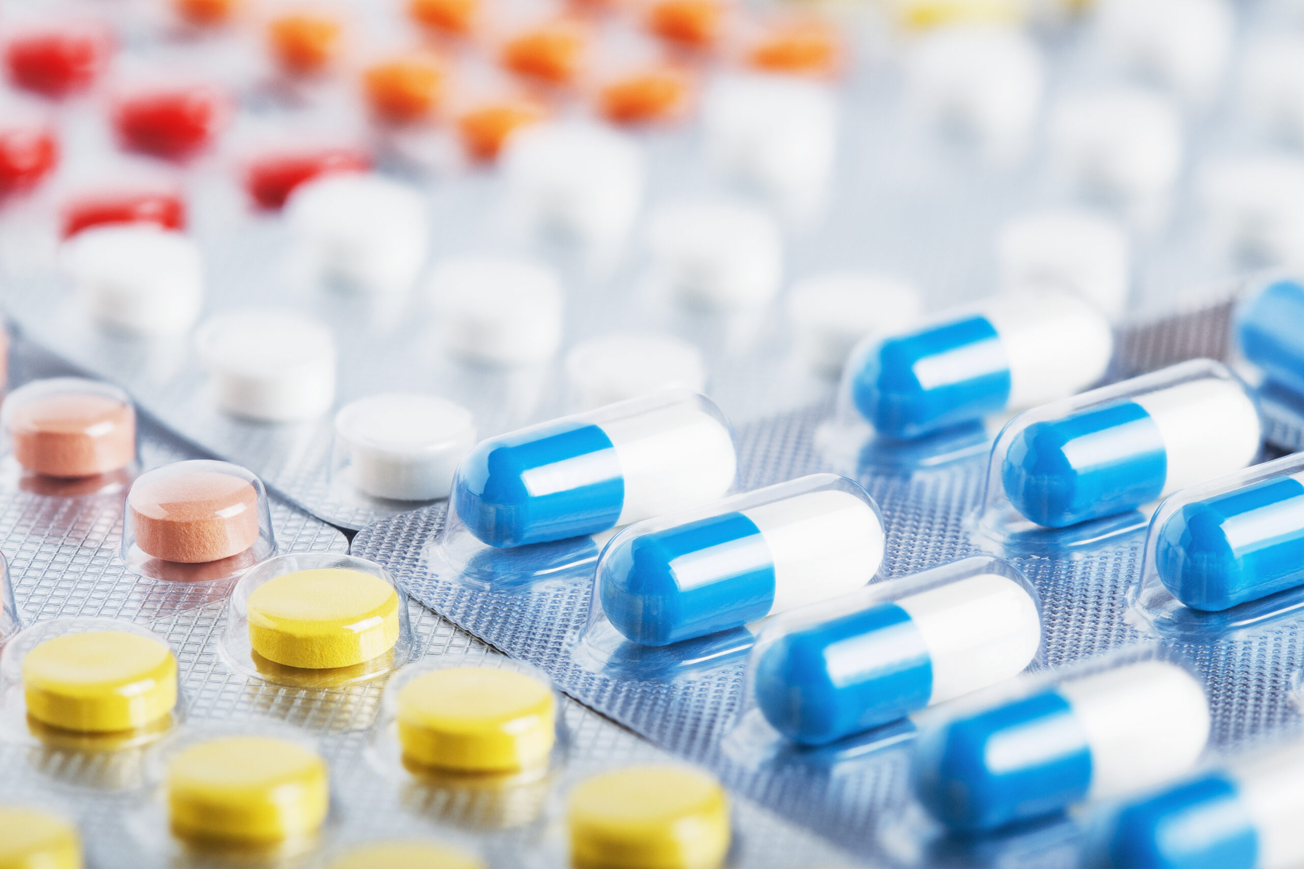Heap of medical pills in white, blue and other colors. Pills in